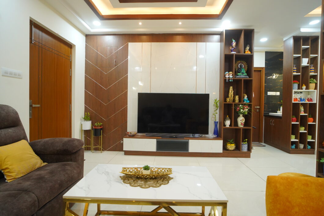 An interior designer's living room project showcasing a stylish TV with panels, cabinets and storage boxes, False Ceiling and elegant table- Aparna Sarovar Zenith - Nallagandla - Dream Modular.