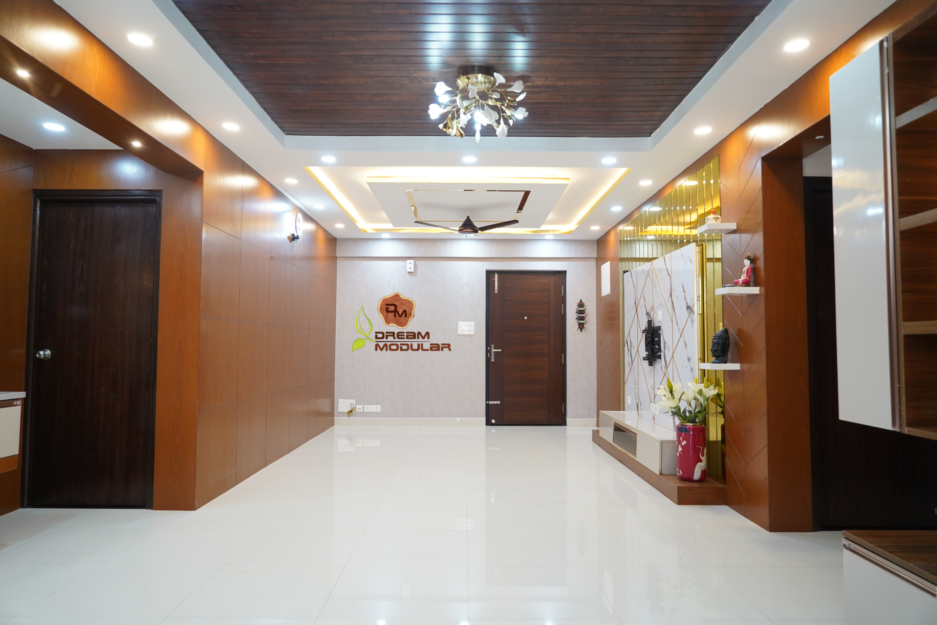 A hallway interior design with a wooden ceiling, Tv Unit with golden stripes and white walls with wooden panels in Hyderabad.