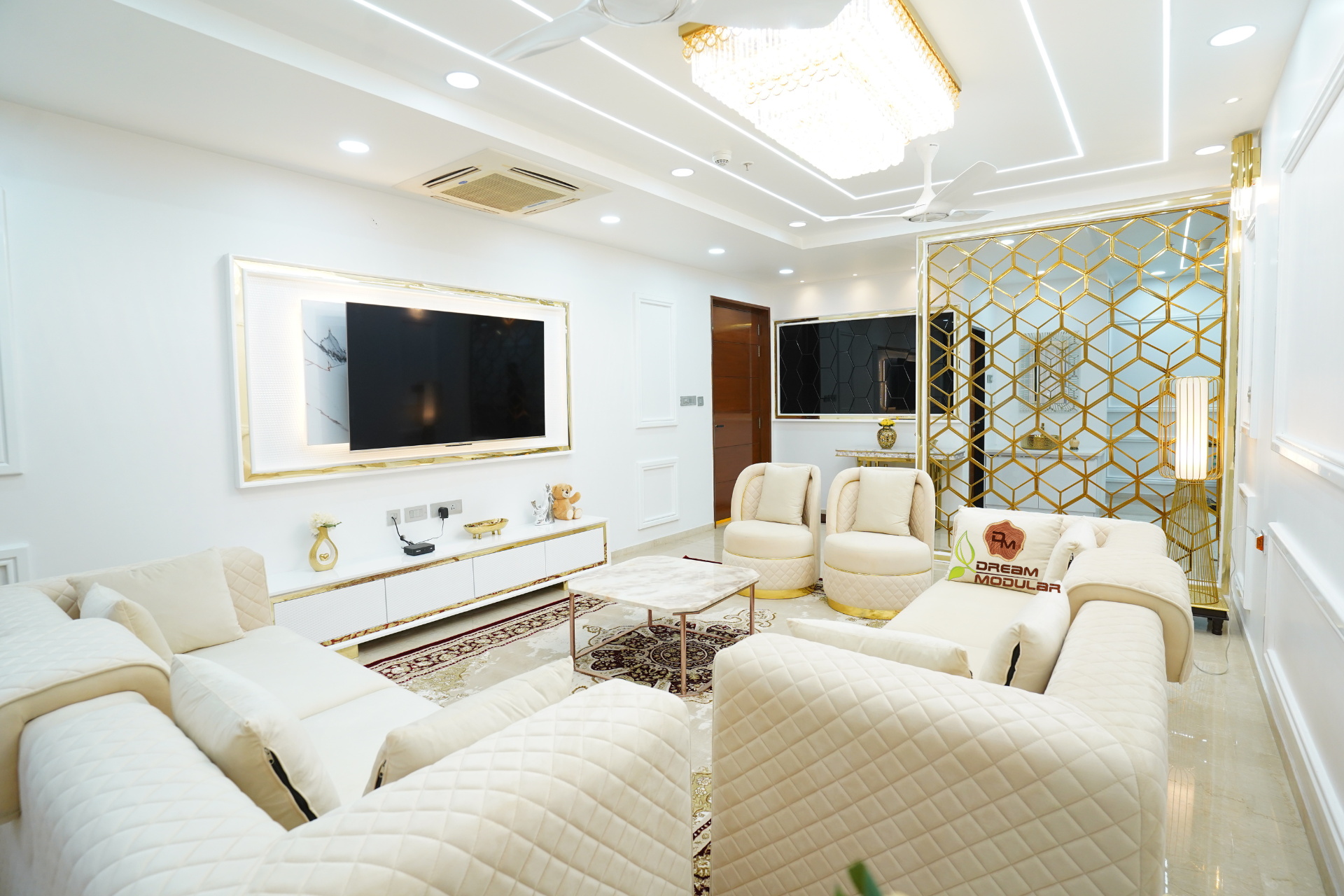 An elegant living room with white furniture and a TV, showcasing impeccable interior design.